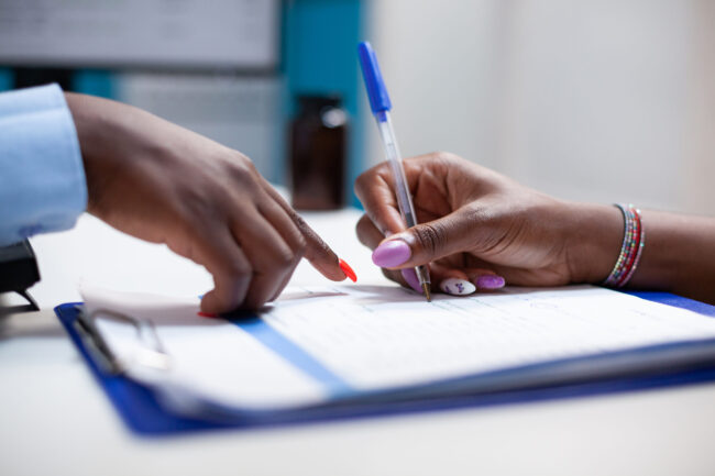 Patient signs medical insurance form